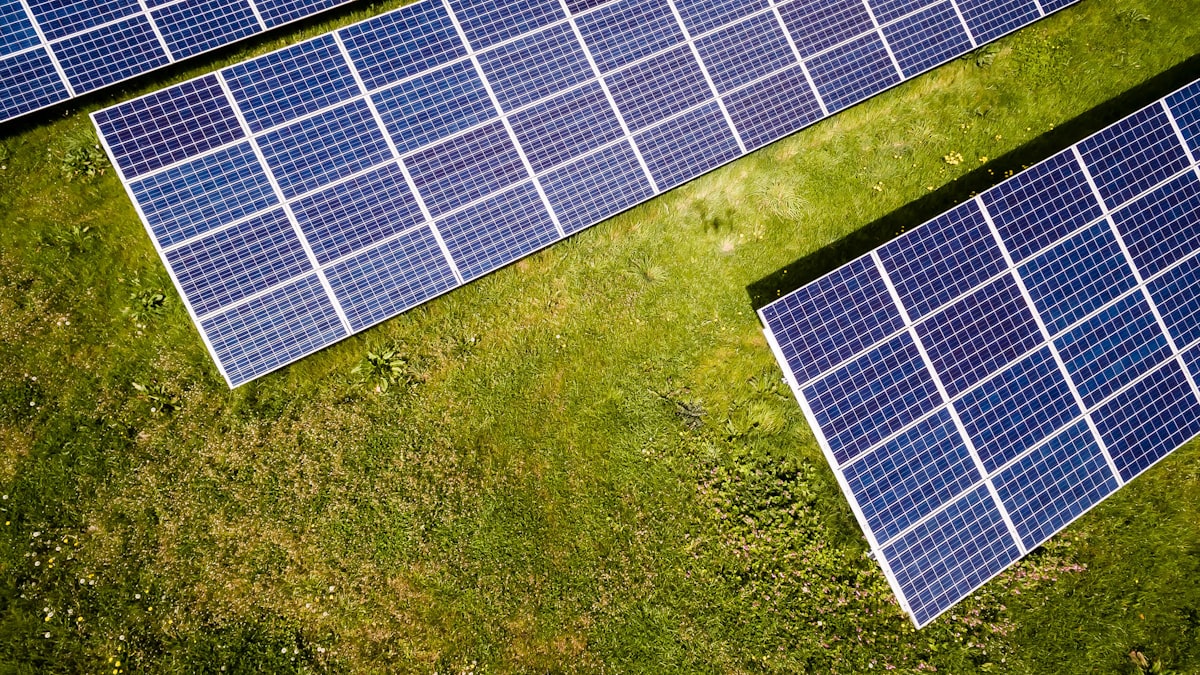 Aerial view of solar panels on green field